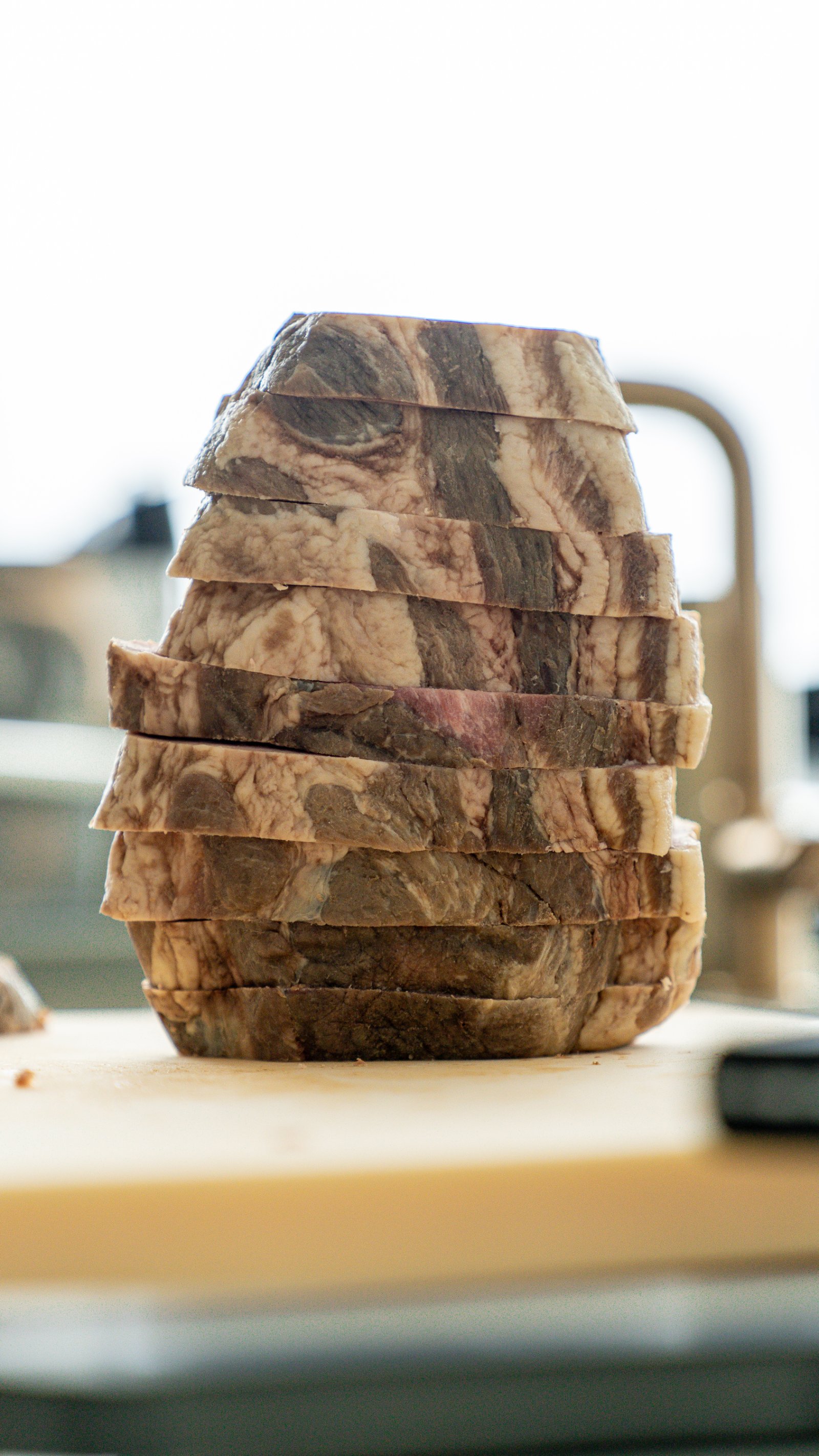 Stack of sliced pork collar showing the marbled cross-section